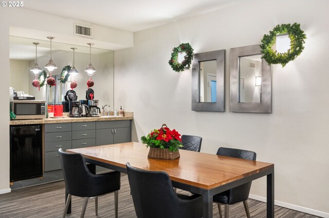 dining area featuring sink and dark wood-type flooring