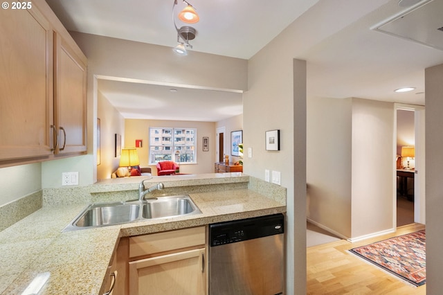 kitchen with light brown cabinetry, light wood-type flooring, stainless steel dishwasher, and sink