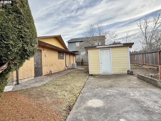 exterior space with central air condition unit, an outdoor structure, and fence