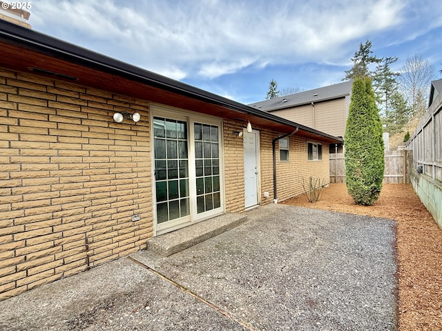 back of property featuring brick siding, a patio area, and a fenced backyard