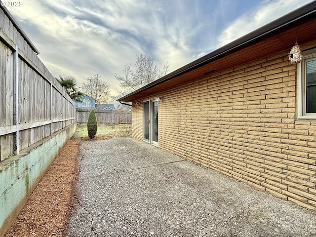 view of home's exterior featuring a patio area, a fenced backyard, and brick siding