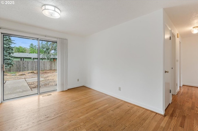 10700 NE 46th St, Vancouver, WA 98682 - spare room featuring light wood-type flooring, baseboards, and a textured ceiling