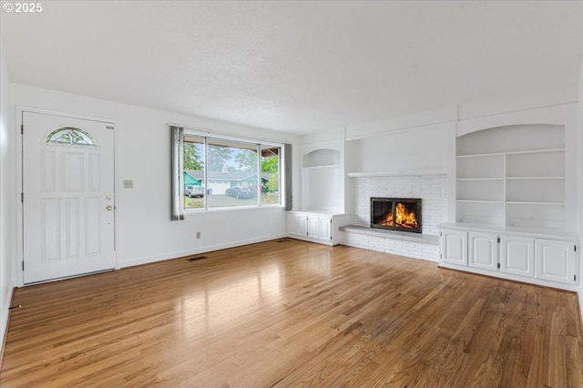 10700 NE 46th St, Vancouver, WA 98682 - unfurnished living room featuring light wood-type flooring, built in features, a fireplace, and baseboards
