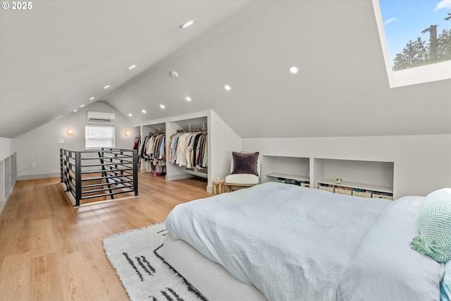 12718 SE 28th Ave, Milwaukie, OR 97222 - bedroom featuring a wall unit AC, wood finished floors, lofted ceiling, a skylight, and recessed lighting