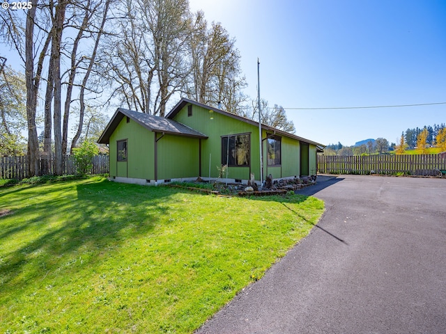 view of front of property featuring driveway, crawl space, a front lawn, and fence