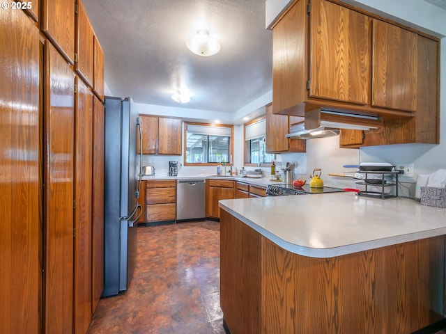 kitchen with stainless steel appliances, exhaust hood, light countertops, a peninsula, and brown cabinetry
