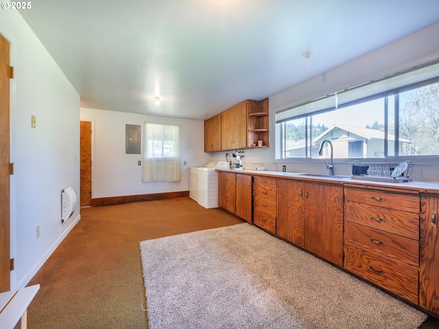 kitchen with open shelves, a sink, baseboards, washer and dryer, and brown cabinetry