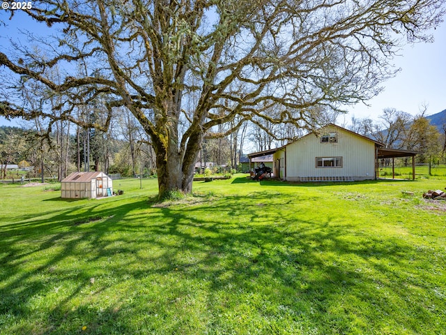 view of yard with a carport and an outbuilding
