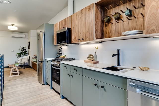 kitchen featuring stainless steel appliances, a wall mounted AC, sink, and light hardwood / wood-style flooring