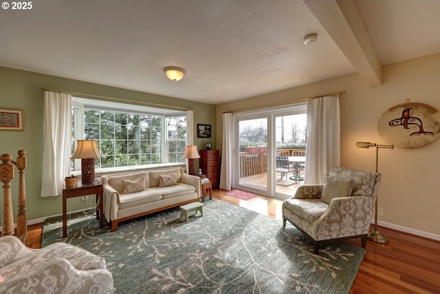 sitting room with beam ceiling, baseboards, and wood finished floors