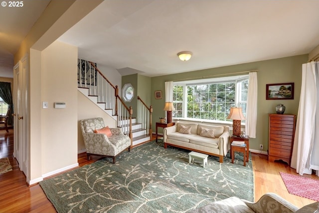 living area with stairway, wood finished floors, and baseboards