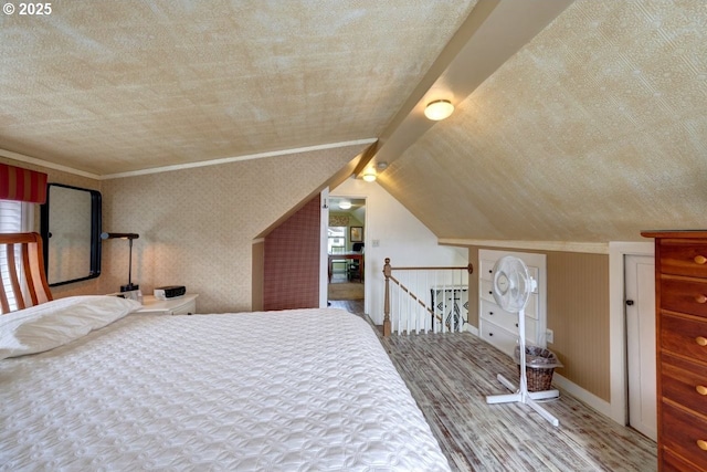 bedroom featuring ornamental molding, vaulted ceiling, and wood finished floors