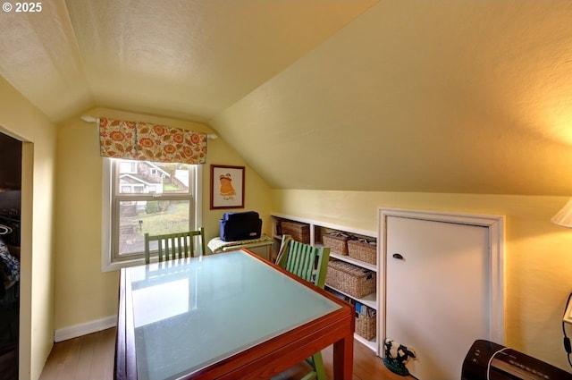 home office with lofted ceiling, baseboards, and wood finished floors