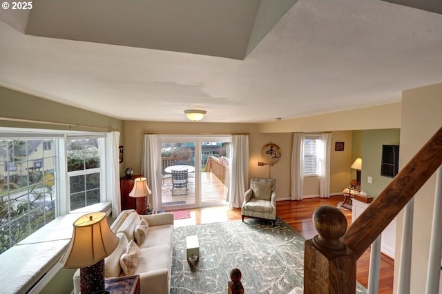 living area with a wealth of natural light, baseboards, and wood finished floors