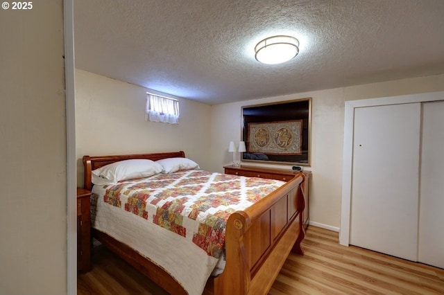 bedroom with light wood-style flooring and a textured ceiling