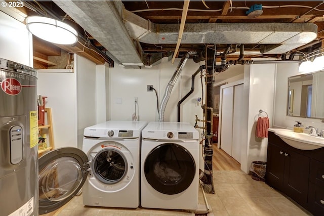 laundry area with laundry area, water heater, a sink, and washer and clothes dryer