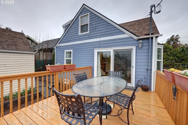 wooden deck featuring an outbuilding and outdoor dining area