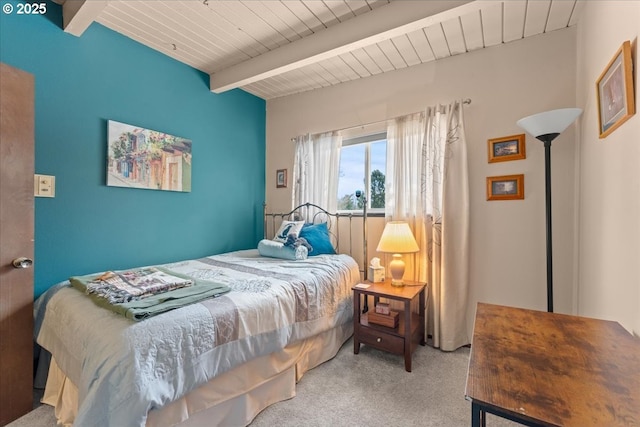 carpeted bedroom featuring beamed ceiling and wood ceiling