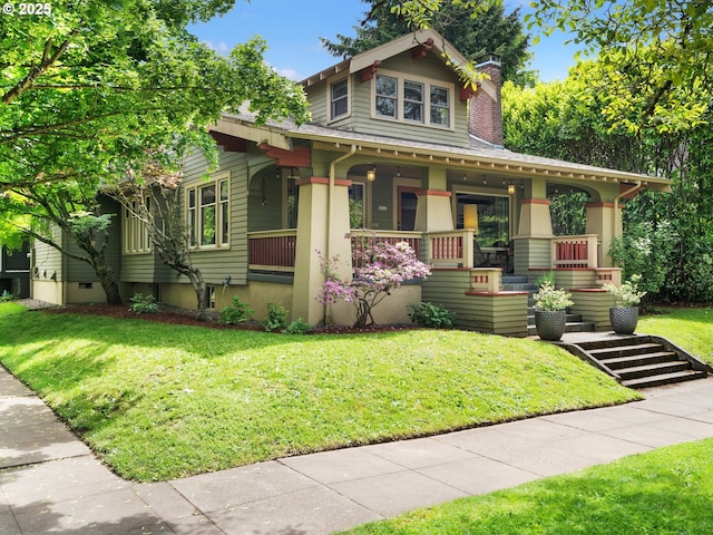 view of front of home with a porch, a chimney, and a front lawn