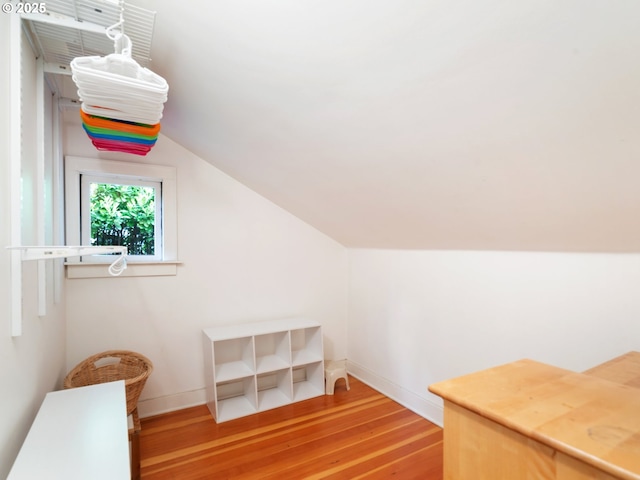 additional living space featuring wood finished floors, baseboards, and lofted ceiling