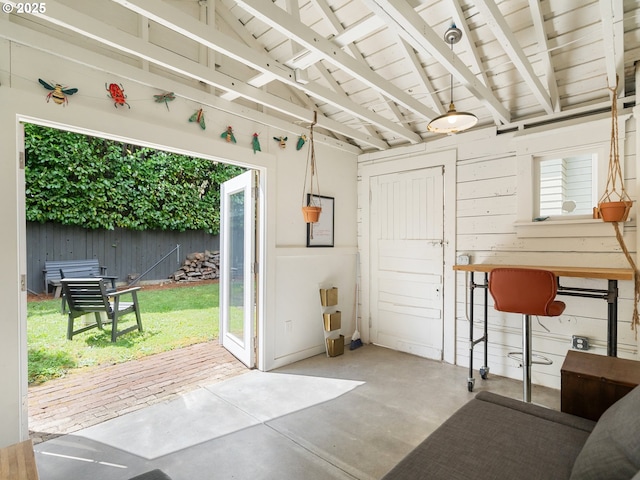 doorway to outside with concrete floors and wooden ceiling