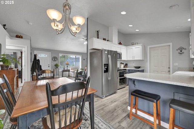 dining space with light wood-style flooring, a chandelier, ceiling fan, and recessed lighting