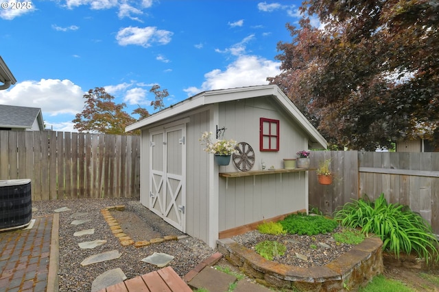 view of shed featuring central AC and a fenced backyard