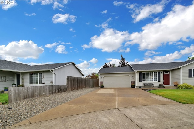 view of front of house featuring concrete driveway, an attached garage, and fence