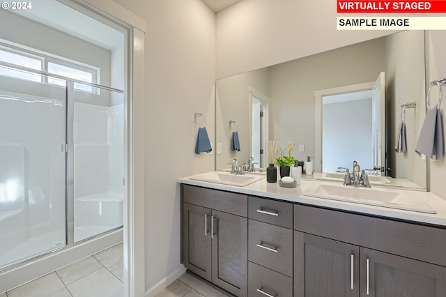 bathroom with double vanity, a shower stall, tile patterned floors, and a sink