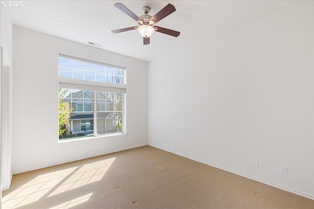 spare room featuring carpet floors, visible vents, and baseboards