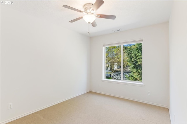 empty room with baseboards, visible vents, and light colored carpet