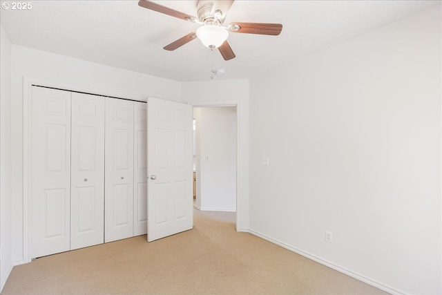 unfurnished bedroom featuring light colored carpet, baseboards, a ceiling fan, and a closet