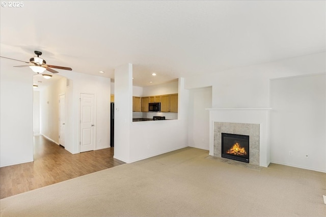unfurnished living room with light carpet, baseboards, recessed lighting, a ceiling fan, and a fireplace