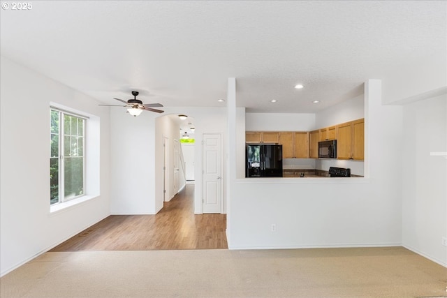 kitchen featuring light carpet, a ceiling fan, recessed lighting, and black appliances