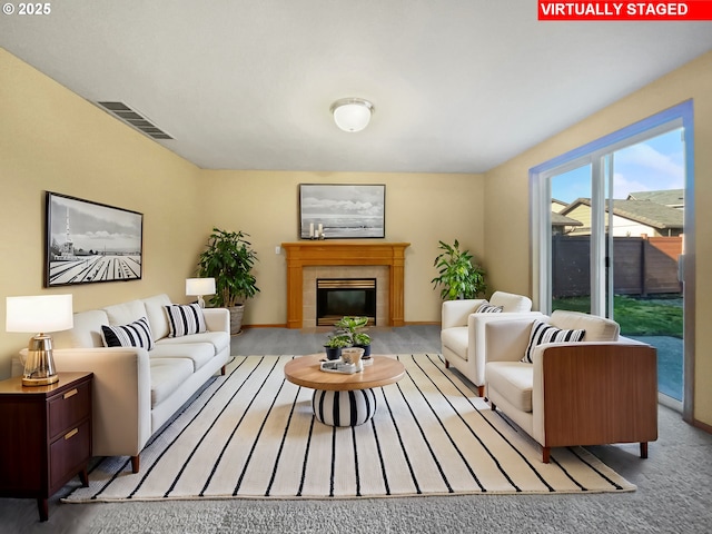 living area featuring light carpet, a fireplace, and visible vents