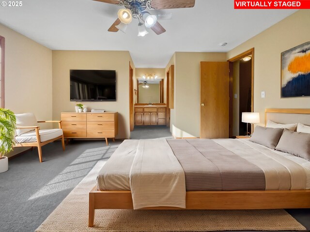 bedroom featuring ensuite bath, carpet flooring, and a ceiling fan