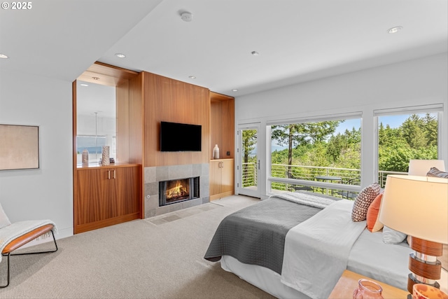 4140 NW Thunder Crest Rd, Portland, OR 97229 - bedroom with access to exterior, light carpet, a tiled fireplace, and recessed lighting