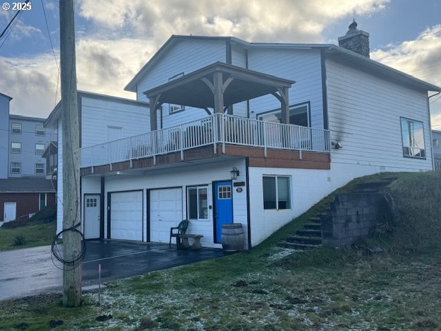 rear view of house with a garage and a balcony