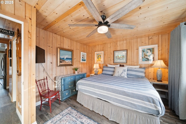 bedroom with dark hardwood / wood-style floors, wooden walls, stainless steel fridge, and wooden ceiling