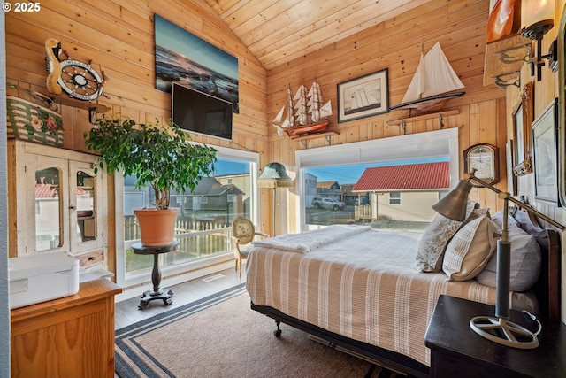 bedroom with wood ceiling, high vaulted ceiling, and wood walls