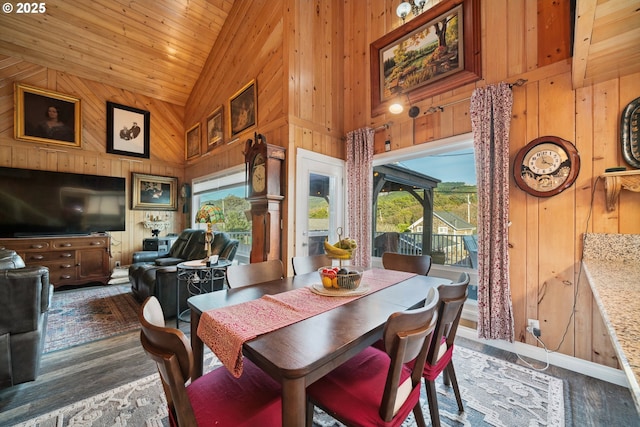 dining space with high vaulted ceiling, dark wood-type flooring, wooden ceiling, and wooden walls