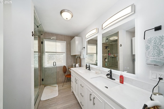 bathroom with walk in shower, vanity, and hardwood / wood-style flooring