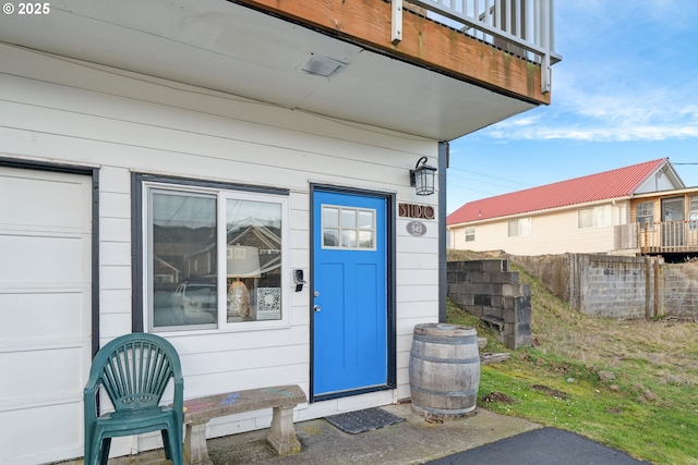 property entrance featuring a balcony and a garage