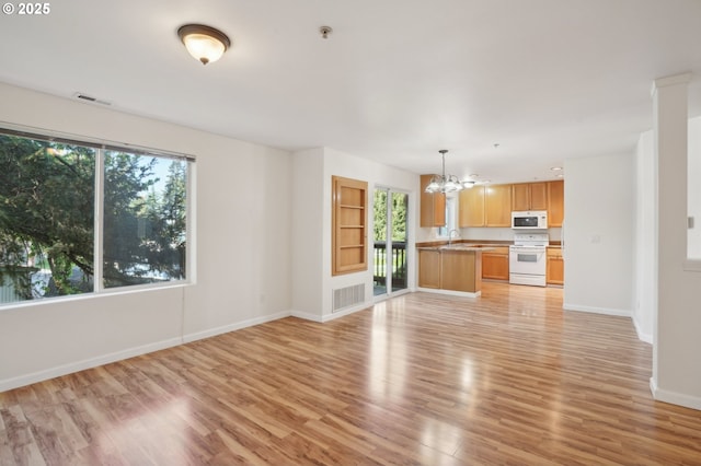 5264 NE 121st Ave Unit K67, Vancouver, WA 98682 - unfurnished living room with a chandelier, a sink, light wood-style flooring, and baseboards