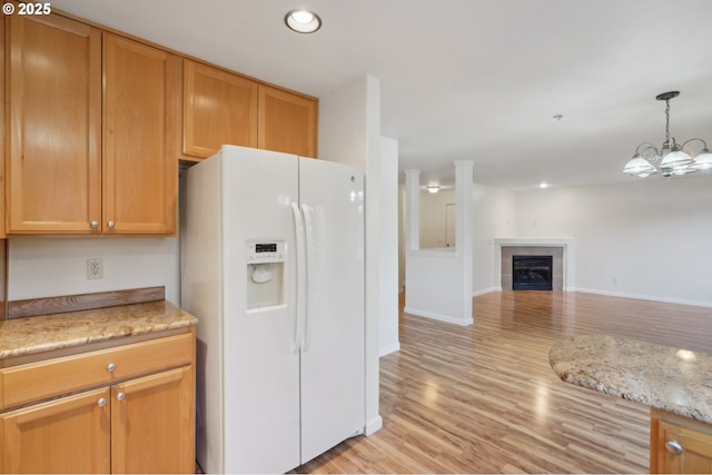 5264 NE 121st Ave Unit K67, Vancouver, WA 98682 - kitchen with white refrigerator with ice dispenser, open floor plan, light wood-type flooring, a tile fireplace, and baseboards