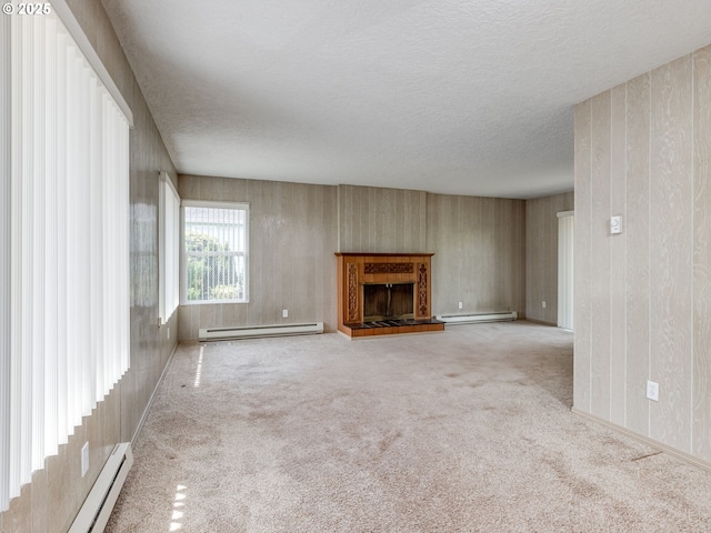 7804 NW 1st Ave, Vancouver, WA 98665 - unfurnished living room featuring baseboard heating, a baseboard radiator, a fireplace with raised hearth, carpet flooring, and a textured ceiling