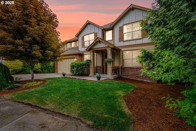 17544 SW Keystone Ct, Beaverton, OR 97007 - view of front of home featuring driveway, a garage, board and batten siding, a yard, and brick siding