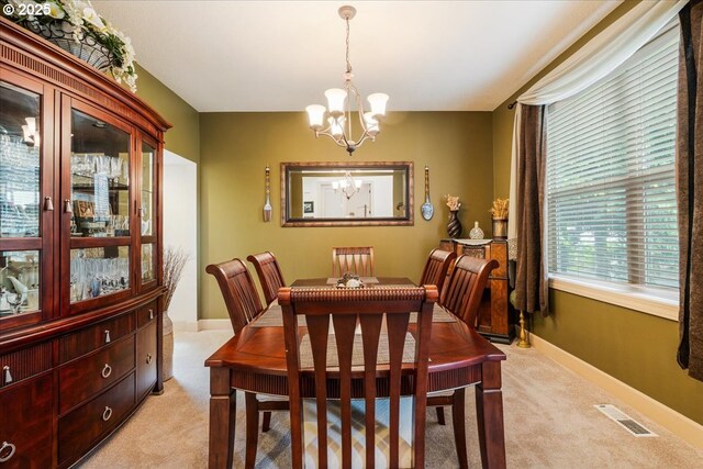 17544 SW Keystone Ct, Beaverton, OR 97007 - dining space featuring light colored carpet, a chandelier, and baseboards