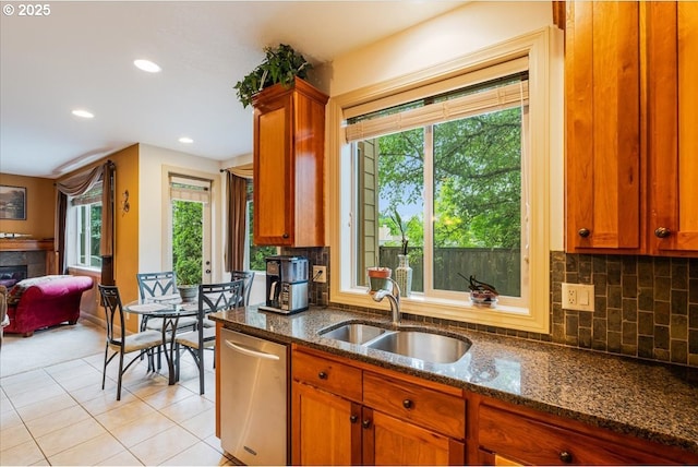 17544 SW Keystone Ct, Beaverton, OR 97007 - kitchen with dishwasher, a sink, dark stone counters, decorative backsplash, and brown cabinets