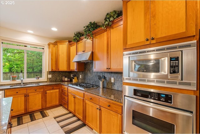 17544 SW Keystone Ct, Beaverton, OR 97007 - kitchen with appliances with stainless steel finishes, a sink, under cabinet range hood, decorative backsplash, and light tile patterned flooring